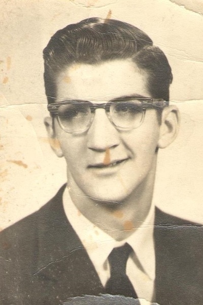 School portrait of young man with glasses and suit