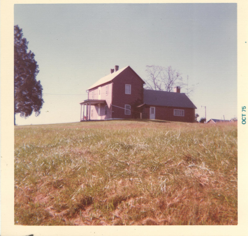 Front yard in foreground with farm house in background 