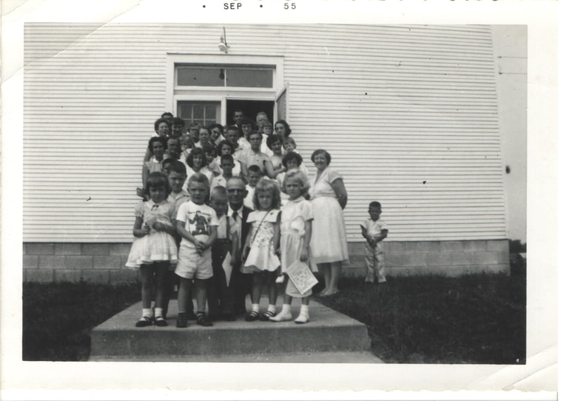 Large group of children and adults at building