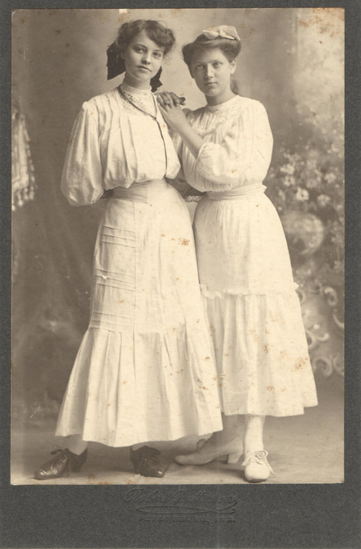 Young women in white dresses standing together