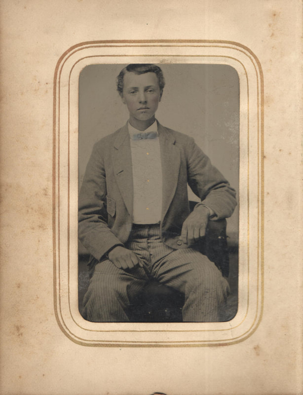 Young man seated in suit and bow tie
