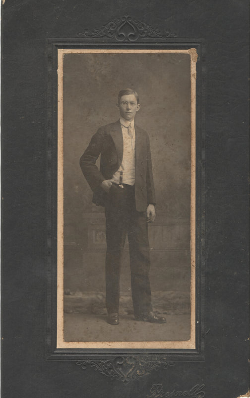 Young man in glasses and suit standing