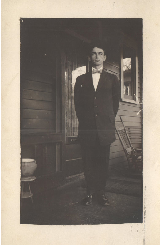Young man in bow tie and suit standing on porch