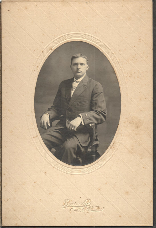 Young man in suit seated in chair 