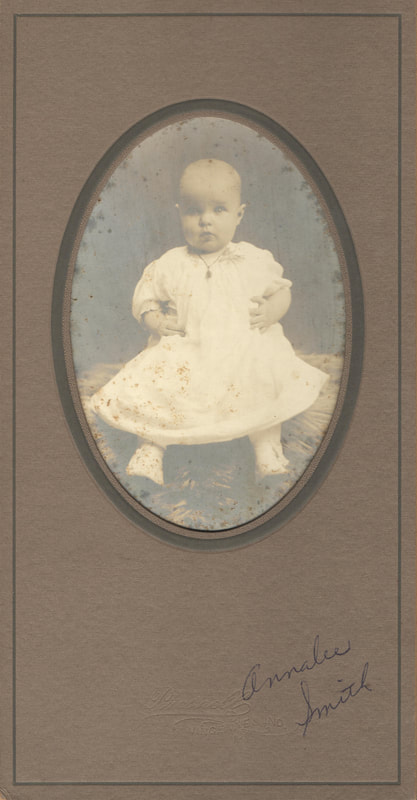 Baby girl seated in gown