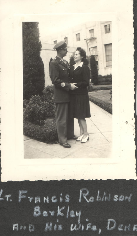 Soldier and wife embracing in front of building