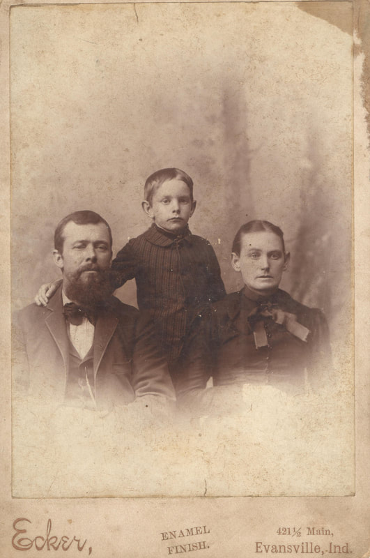 Man with beard, child, and woman in dress clothes seated together