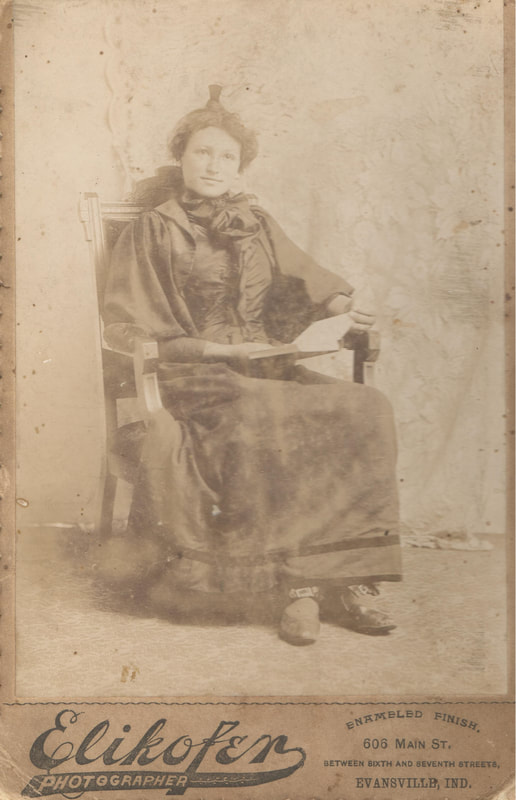 Woman seated with book in chair