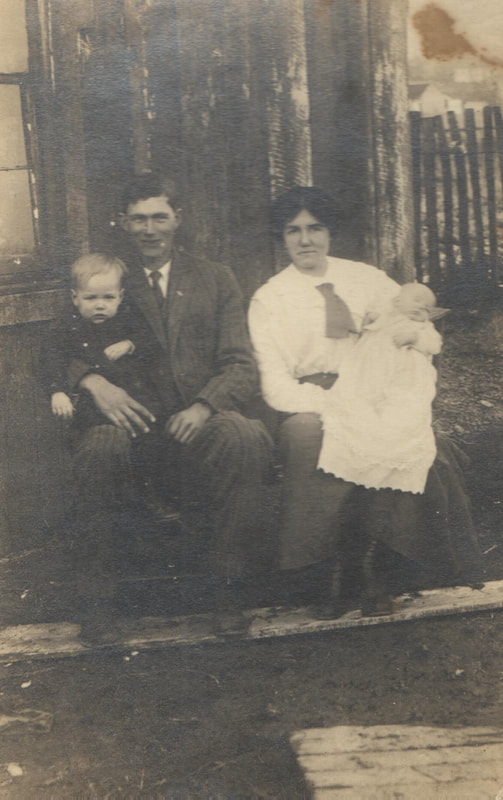 Man and woman in dress clothes seated with small children