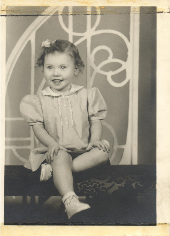 Young girl with bow in hair seated 