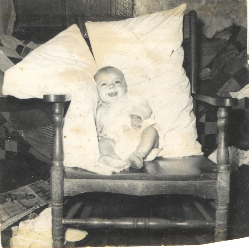 Baby girl propped up on chair with pillows
