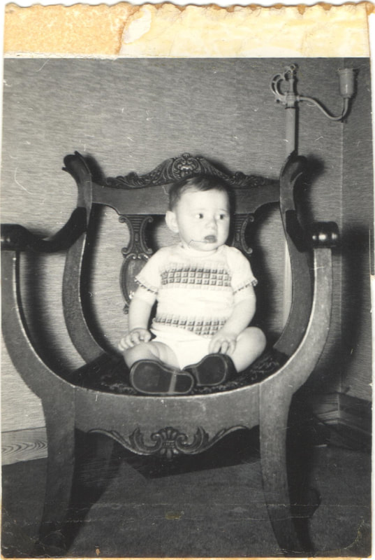 Baby boy seated on chair