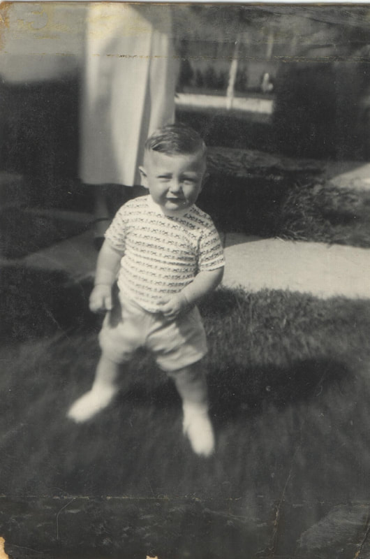 Young boy in shorts and t-shirt standing in yard