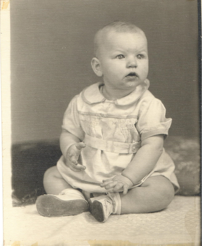 Young boy seated on blanket
