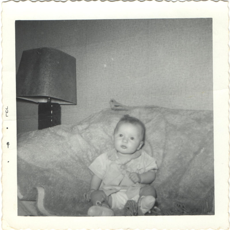 Baby girl seated on couch