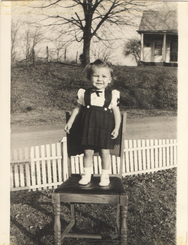 Young girl in bowtie standing on chair