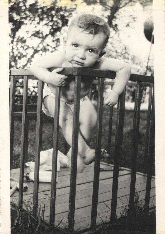 Baby boy climbing out of crib
