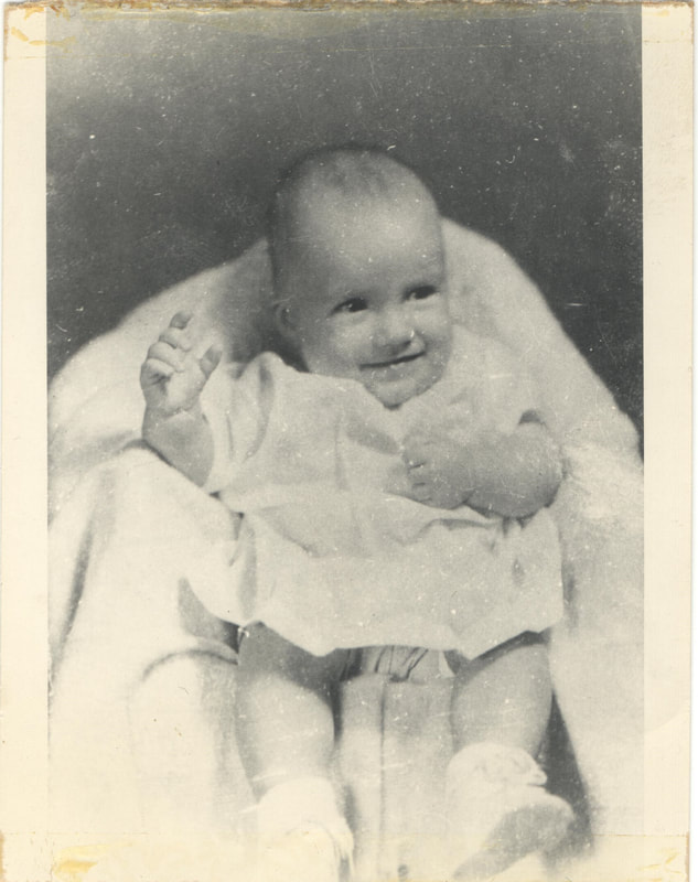 Smiling baby girl lying in carriage 