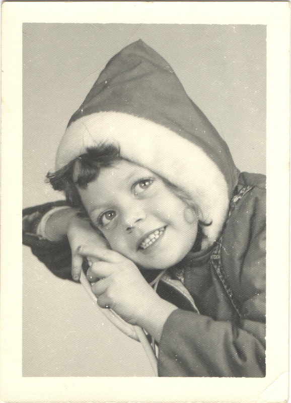 Young girl in winter coat with hands rested on face
