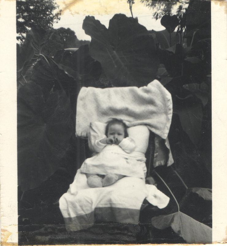 Baby with hands on face in carriage