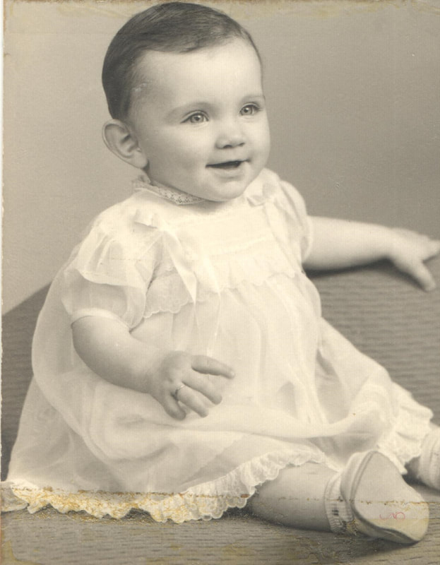 Baby girl with dark hair seated