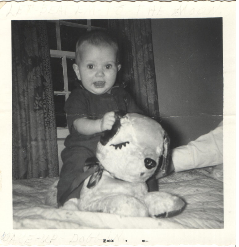 Baby boy seated on stuffed toy dog