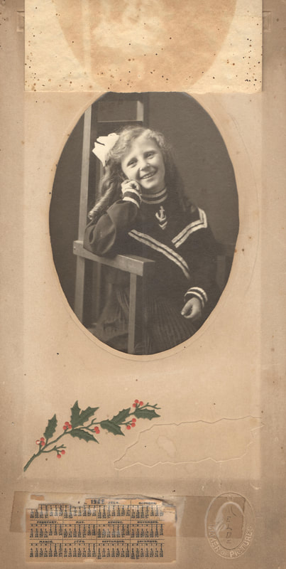 Young girl in sailor suit seated on chair