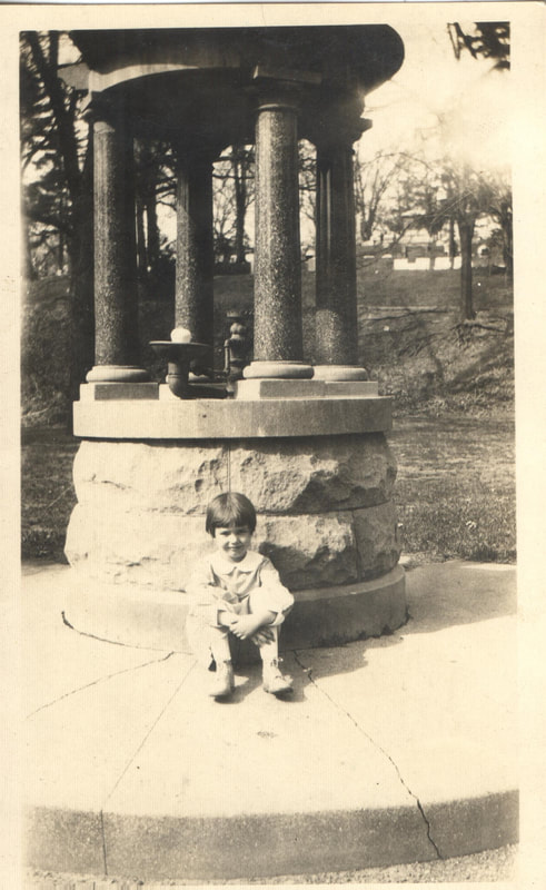 Young girl seated next to fountain