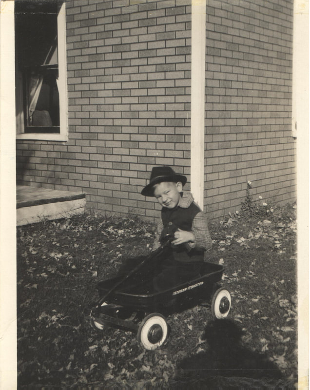 Young boy with hat seated in wagon