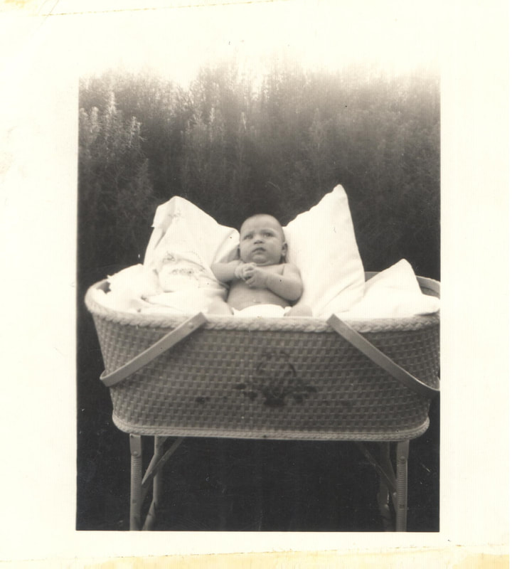 Baby girl propped up on pillow in basket