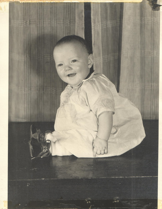 Baby girl in gown seated