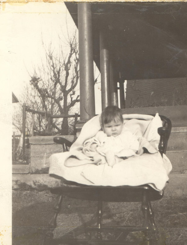 Baby girl seated in chair wrapped in blankets