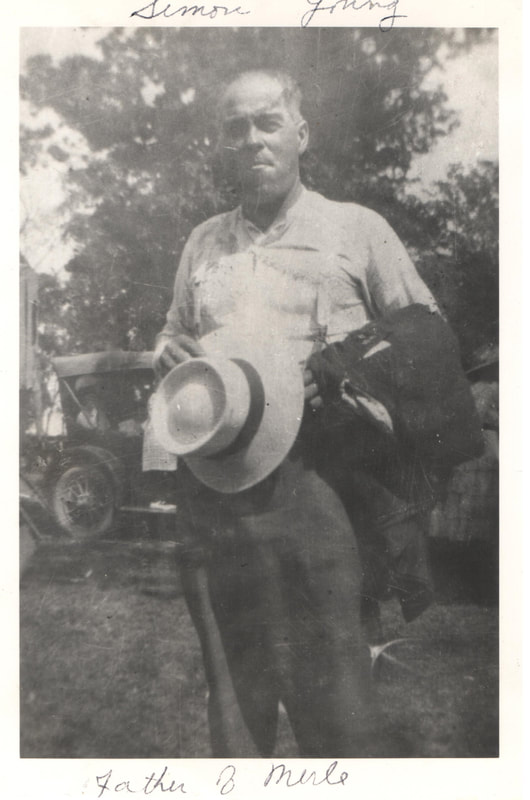 Elderly man holding hat standing outdoors