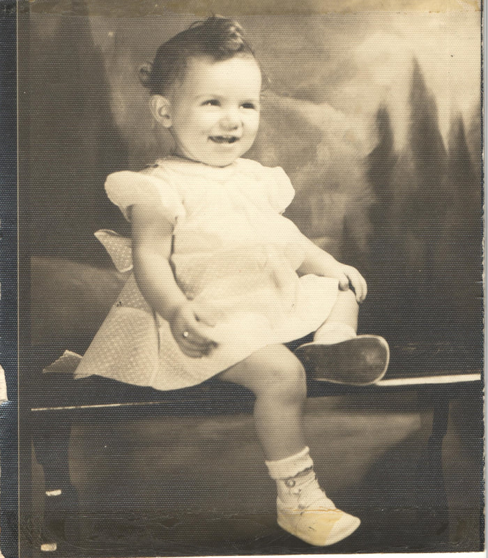 Baby girl seated on bench