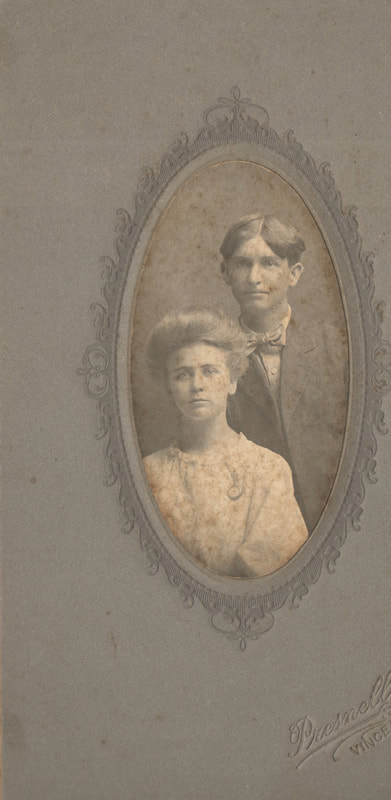 Young man and woman in dress clothes seated together