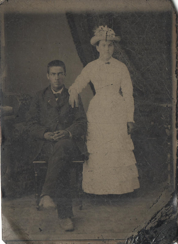 Young man seated next to young woman with had standing