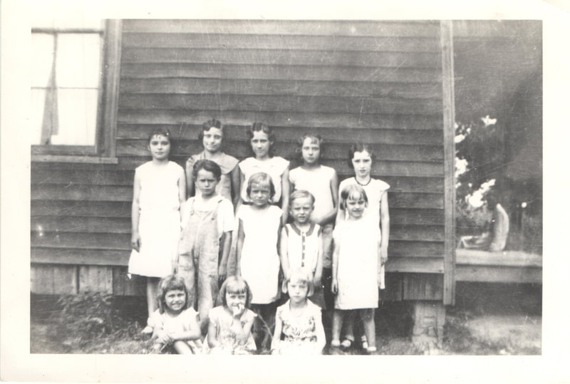 Young children standing together near side of house