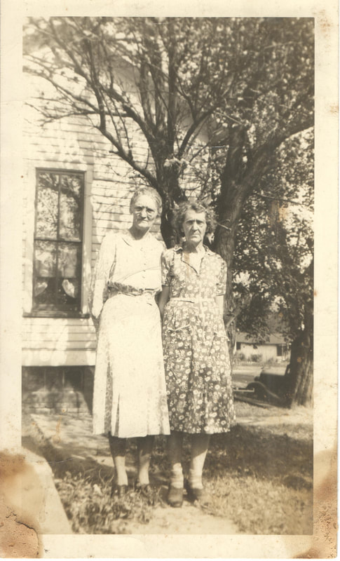 Elderly women standing in front of house
