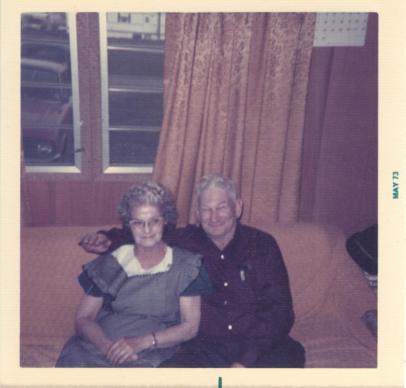 Elderly couple seated on couch