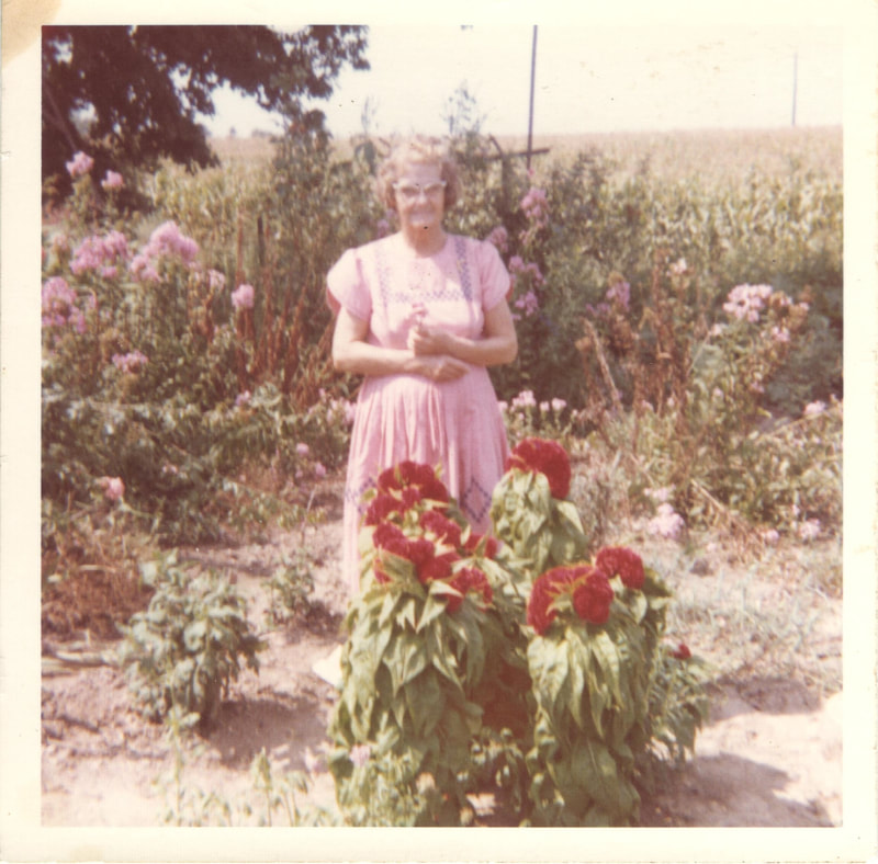 Elderly woman standing in flower garden