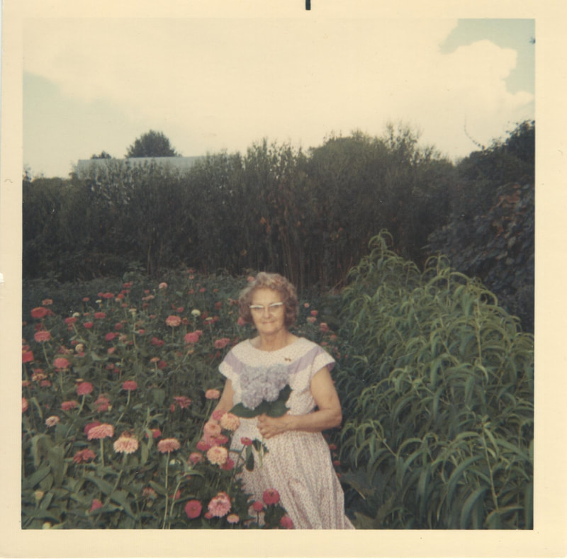 Woman holding leaf in flower garden