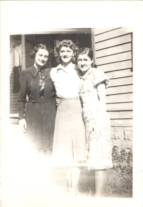 Young women standing together in front of home