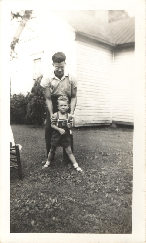 Man holding young boy in overalls