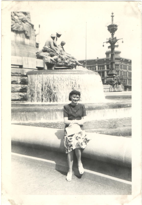 Woman sitting in front of monument and fountain