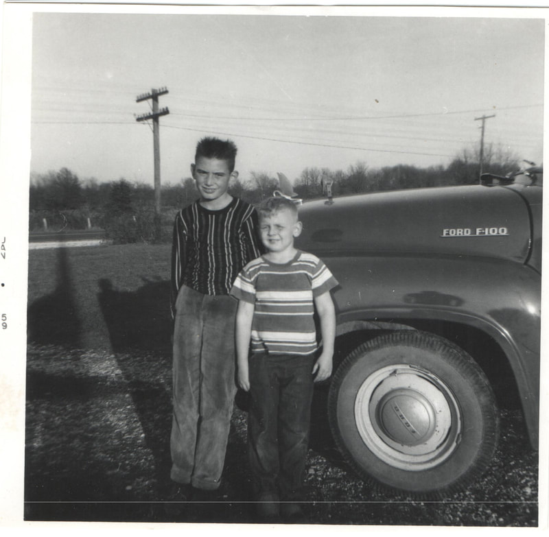 Young boys standing next to Ford vehicle