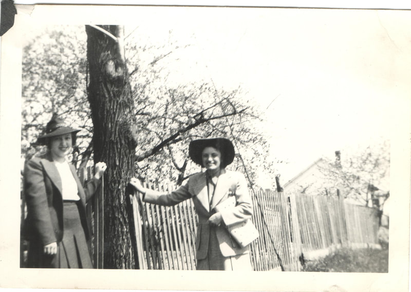 Women in hats standing next to fence