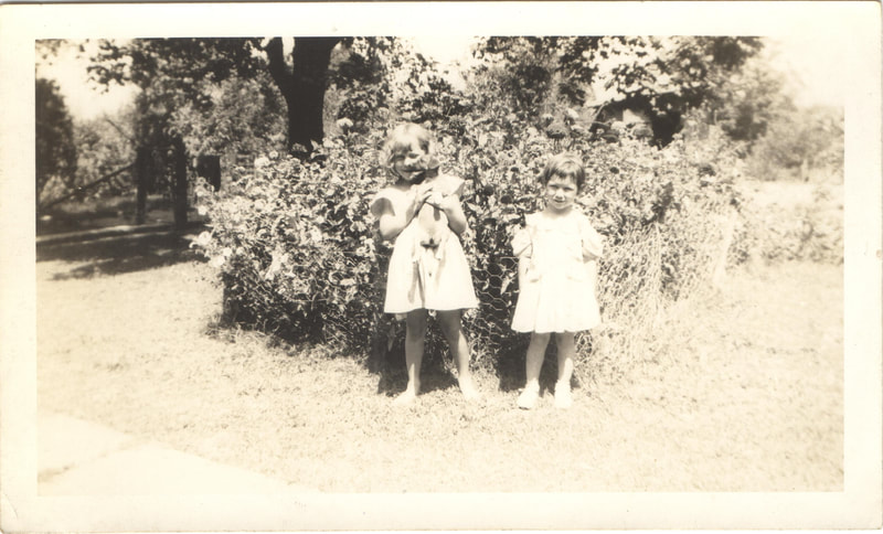 Young girls standing near garden