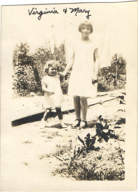 Girl and young young girl holding hands in garden