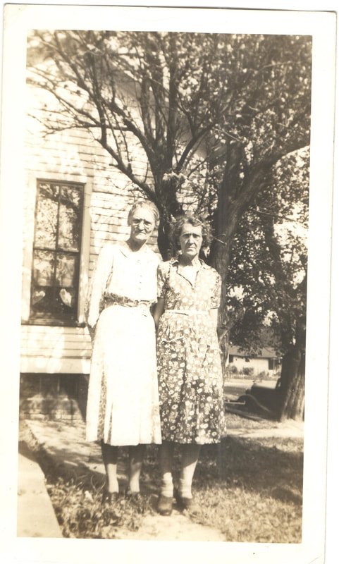 Elderly women standing next to house