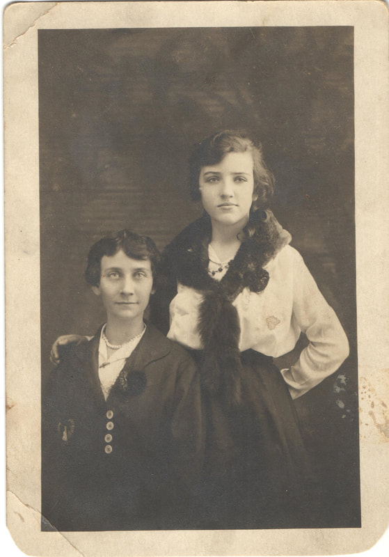 Young woman standing next to seated young woman